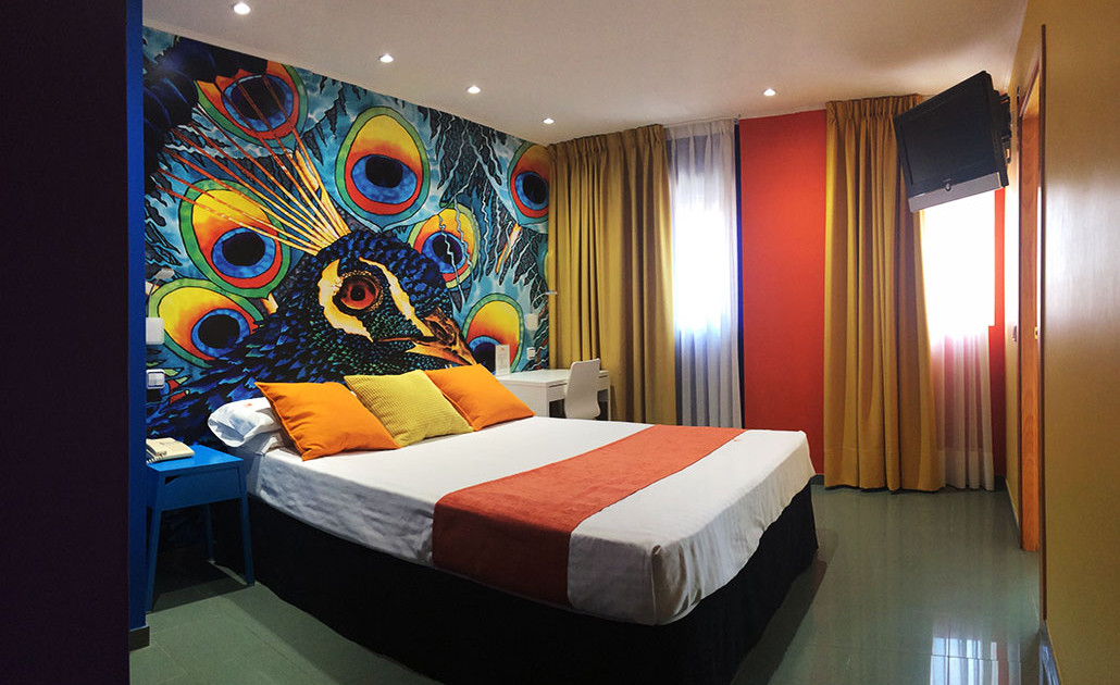 habitación doble decorada con pavo real de colores